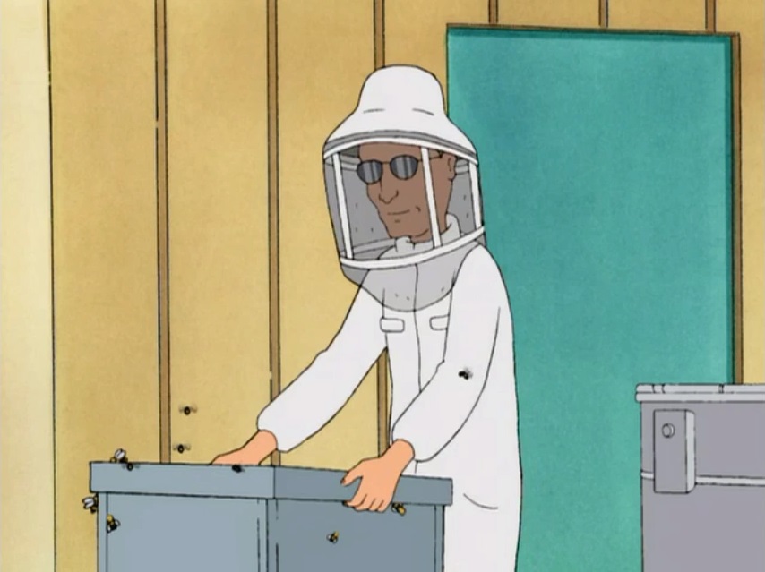 Dale moving a box of bees in a beekeeper suit